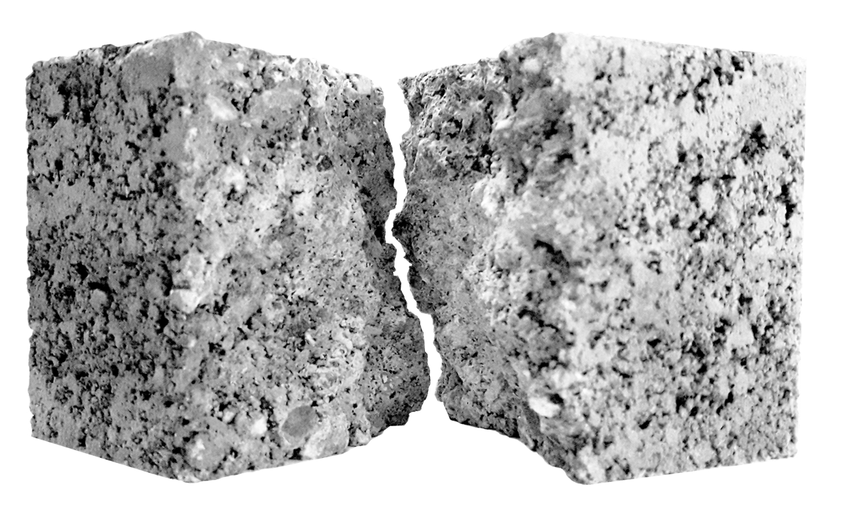 Zwei Stück heller Beton mit schwarzen Punkten. In der Mitte ist eine raue Rissfläche.